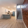 Photo 8: Shared living space with exposed brick.