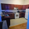 Photo 4: Shared modern large kitchen and cabinets to store nonperishable food items.