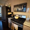 Photo 3: The kitchen - fridge, microwave, gas stove, food storage.