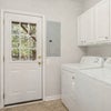 Photo 5: First-floor laundry room with exterior door to the covered under-deck area — convenient additional
