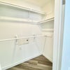 Photo 5: Multiple clothing racks and shelving options in the 7 ft wide walk-in closet.