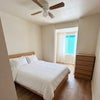 Photo 3: Bright furnished bedroom with comfortable bed and storage space