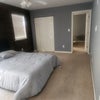Photo 4: Large room with a dresser and a bed.