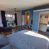 Photo 3: Queen bed and mirrored closet with hanging space, shelving, and provided hangers.