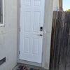 Photo 6: Private exterior entrance with keypad access, security light, and dedicated entry mat.