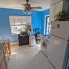 Photo 7: Separate kitchen shared by renters, with full-size fridge, stove, microwave, and dining table.