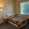 Photo 4: Bedroom #1 with walk-in-closet + bed, bedding, desk, chair, floor lamp, ceiling fan.