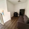 Photo 5: Living room area with sofa, fridge and microwave outside room