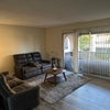 Photo 4: Living room is furnished with a large TV and the balcony has a couch table and chair