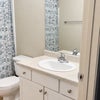 Photo 4:     Shared bathroom with vanity and cabinet storage